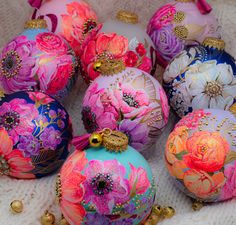 a bunch of ornaments that are sitting on a blanket together, all decorated in different colors and designs