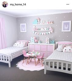 a room with two beds and pink furniture