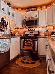 a kitchen decorated for halloween with pumpkins and decorations