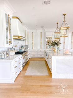 a large kitchen with white cabinets and gold trim on the doors, counter tops and drawers