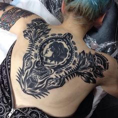 a person with tattoos on their back laying down