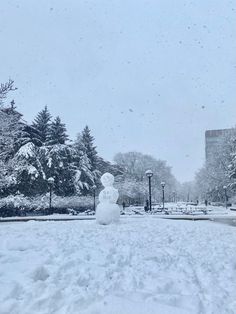 a snowman in the middle of a snowy park