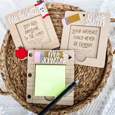 four personalized notepads on a woven basket with a pen and paper attached to them