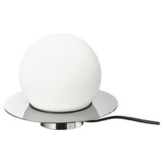 a white light sitting on top of a metal plate with a cord attached to it