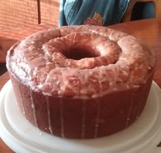 a bundt cake sitting on top of a white plate next to a wooden table