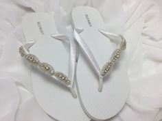 White bridal flip flops are wrapped with white satin ribbon and the straps are decorated with a rhinestones trim with beads Ribbon color is white if you are needing other colors of ribbon or decoration please contact me and will be happy to accommodate you! All flip flops are handmade to order and the production time is 5-7 business days and then please allow additional time for shipping.  On a larger order please contact me. Amazing for beach, weddings, flower girl or a fancy event, you choose! Elegant Silver Beach Flip Flops, Elegant Rhinestone Wedding Flip Flops, Elegant Rhinestone Flip Flops For Wedding, Elegant Wedding Flip Flops With Rhinestones, White Sandals With Rhinestones And Adjustable Fit, White Open Toe Flip Flops For Wedding, White Adjustable Flip Flops For Wedding, Adjustable White Flip Flops For Wedding, Flip Flops Wedding