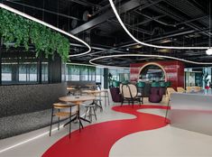 a restaurant with red and white flooring, chairs, tables and plants hanging from the ceiling