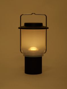 a light that is on top of a black stand with a white light in the middle