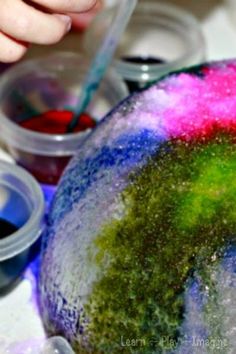 a child is painting on an object in the process of being made with acrylic paint