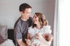 a man and woman holding a baby in their arms