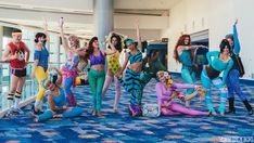 a group of women dressed in costumes posing for a photo with each other on the floor