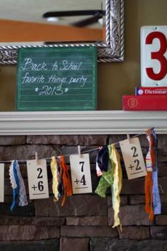 a fire place with ribbons hanging from it's mantle and a chalkboard on the wall