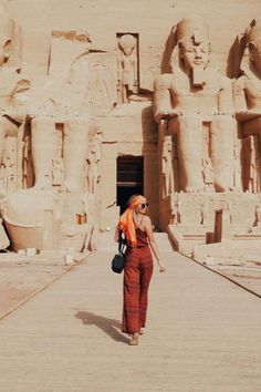 a woman standing in front of an egyptian temple