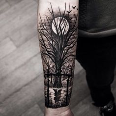 a man's arm with a tree and birds in the night sky on it