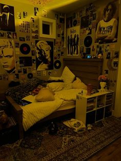 a bed room with a neatly made bed and lots of pictures on the wall