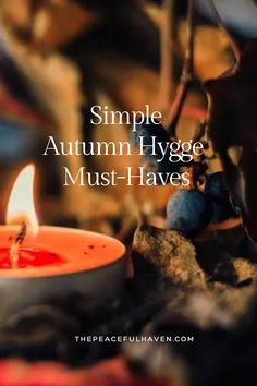 an orange candle with the words simple autumn hygge must - haves