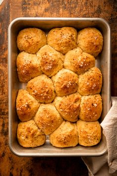 freshly baked rolls in a baking pan on a wooden table