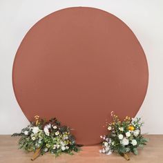 two vases with flowers sit in front of a large circle