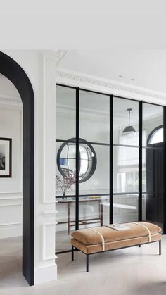 an elegant living room with black and white decor on the walls, arched doorways and glass doors