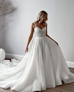 a woman in a white wedding dress is standing on the floor with her back to the camera