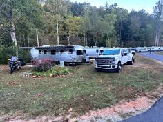 an rv park with several recreational vehicles parked on the grass and trees in the background