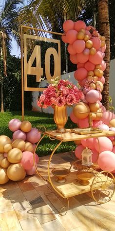 a table topped with balloons and flowers next to a sign that says 40 on it