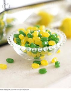 green and yellow candies in a glass bowl