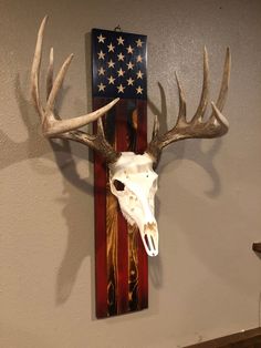 a deer skull mounted to the side of a wall with an american flag painted on it