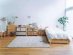 a bedroom with white walls and wooden floors, including an area rug that has been placed on the floor