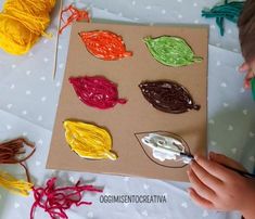 a young boy is working on crafts with string and yarns in the shape of leaves