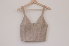 a cropped tank top hanging on a wooden hanger