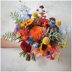 a person holding a bouquet of flowers in their hand