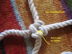 a close up of a piece of white rope on top of a colorful rug with yellow stitching