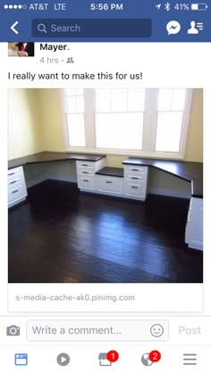 an empty room with white cabinets and black counter tops on the floor, in front of a window