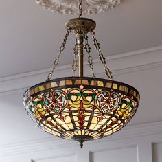 a stained glass chandelier hangs from the ceiling in a room with white walls