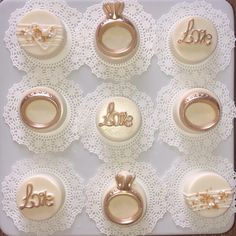 the wedding rings and ring box are decorated with gold lettering on white lace doily