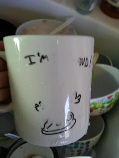 a person holding a coffee mug with writing on it