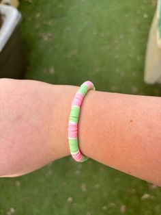 A clay bead bracelet with pink and green with a little bit of white that's 6 and a half inches long Pink Hand-strung Heishi Beads Friendship Bracelets, Trendy Green Heishi Beads Bracelets, Casual Green Heishi Beads Stretch Bracelet, Casual Pink Hand-strung Friendship Bracelets, Trendy Green Heishi Beads Stretch Bracelet, Green Heishi Beads Friendship Bracelet, Green Heishi Beads Friendship Bracelets, Casual Green Heishi Beads Friendship Bracelets, Bracelets Green