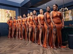 a group of women in orange dresses standing next to each other