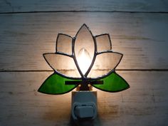 a light that is on the side of a wall with a flower shaped glass shade