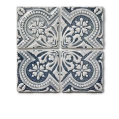 four blue and white tile tiles with floral designs on the bottom, one is square