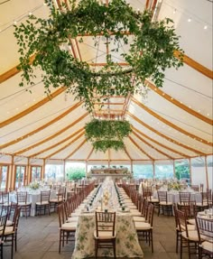 the inside of a large tent with tables and chairs set up for an outdoor wedding