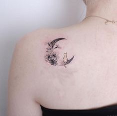 a woman's back shoulder with a cat and moon tattoo on it