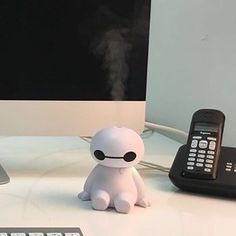 a small toy sitting on top of a desk next to a computer