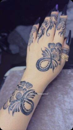 a woman's hand with tattoos on it