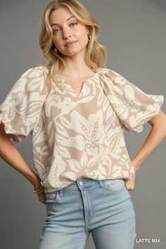 Elevate your wardrobe with our Floral Harmony Balloon Sleeve Top, a perfect blend of contemporary style and feminine charm. Crafted from a blend of 95% polyester and 5% spandex, this top offers a comfortable stretch and a luxurious feel. Featuring a unique two-tone floral print, this top showcases a split neck design that adds a modern twist to its classic silhouette. The balloon sleeves with lining (only in the sleeves) create a dramatic yet sophisticated look, perfect for making a statement wh Beige Relaxed Fit Top For Brunch, Casual Beige Blouse With Balloon Sleeves, Chic Taupe V-neck Top, Feminine Beige Blouse With Lantern Sleeves, Cream Balloon Sleeve Top For Spring, Cream Casual Puff Sleeve Top, Cream Relaxed Fit Top For Brunch, Chic Cream Balloon Sleeve Tops, Casual Cream Balloon Sleeve Top