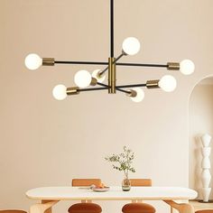 a dining room table with chairs and a chandelier hanging from the ceiling over it