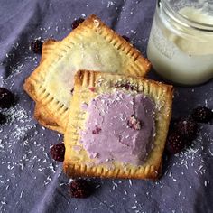 two pastries with ice cream on them next to a glass of milk and some berries