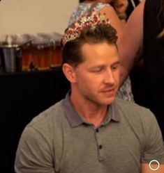 a man wearing a tiara sitting next to a woman