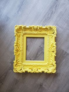 a yellow frame sitting on top of a wooden floor